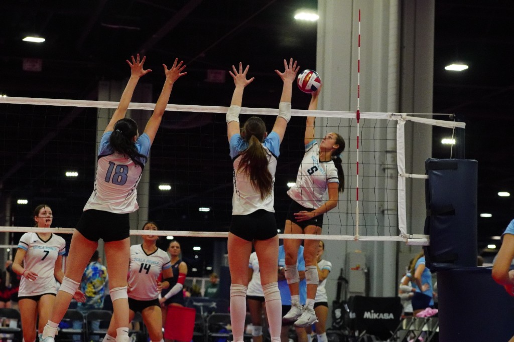 Volleyball players competing at the net during a match